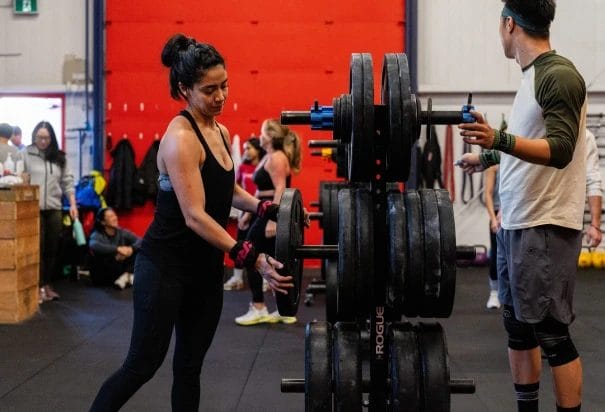 Woman and man preparing weights